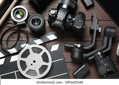 Flat lay composition with camera and video production equipment on brown wooden background - Powered by Shutterstock