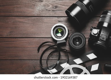 Flat Lay Composition With Camera And Video Production Equipment On Brown Wooden Background. Space For Text