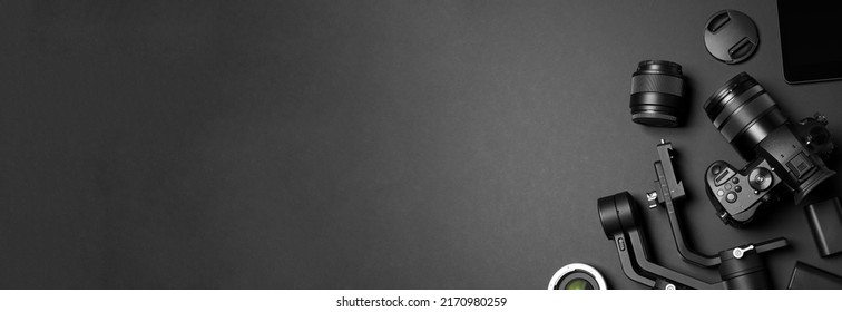 Flat lay composition with camera and video production equipment on black background, space for text. Banner design