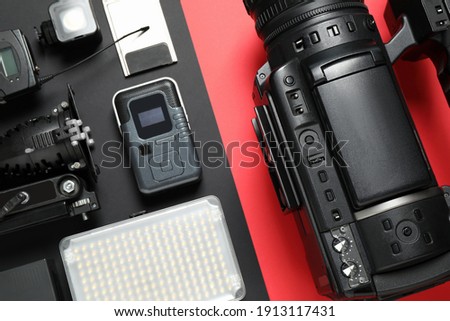 Flat lay composition with camera and video production equipment on color background