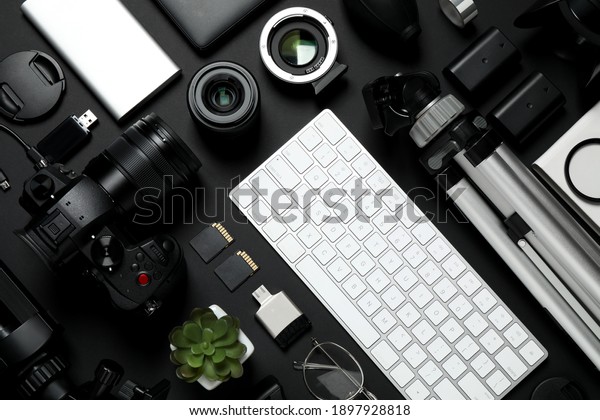 Flat lay\
composition with camera, video production equipment and computer\
keyboard on black\
background