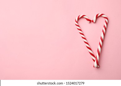 Flat lay composition with candy canes on pink background. Space for text - Powered by Shutterstock
