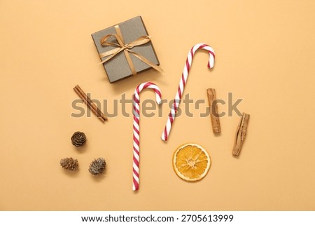 Flat lay composition with candy canes on pale orange background. Christmas treat