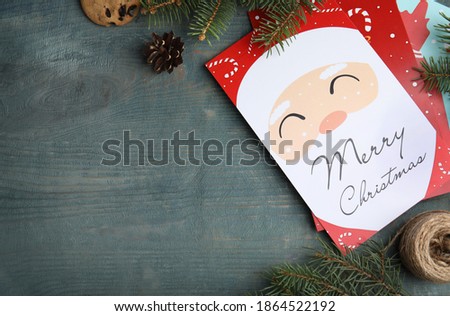 Flat lay composition with Christmas cards on light blue wooden background, space for text