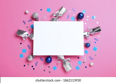 Flat lay composition of Christmas crackers, decorations, shiny confetti and blank paper on pink background. Space for text - Powered by Shutterstock