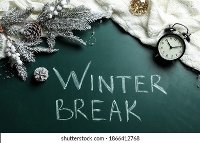 Flat Lay Composition Of Christmas Decorations, Knitted Plaid And Alarm Clock On School Blackboard With Phrase Winter Break