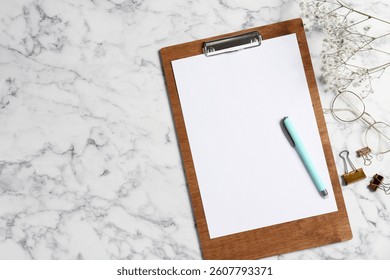 Flat lay composition with clipboard and blank paper on white marble background . Space for text