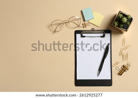 Flat lay composition with clipboard and blank paper on beige background. Space for text