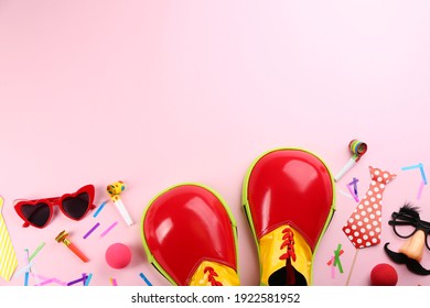 Flat Lay Composition With Clown Shoes And Accessories On Pink Background. Space For Text