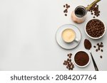 Flat lay composition with coffee grounds and roasted beans on white background, space for text