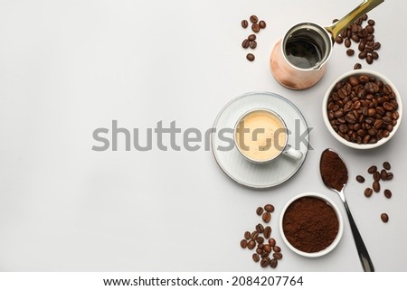 Flat lay composition with coffee grounds and roasted beans on white background, space for text
