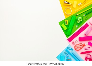 Flat lay composition with colorful school supplies on white background. Blue, pink green and yellow school items top view. - Powered by Shutterstock