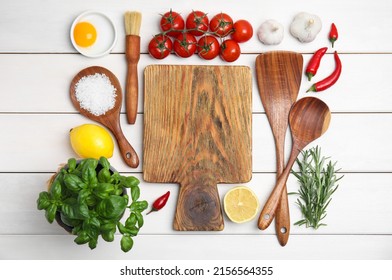 Flat lay composition with cooking utensils and fresh ingredients on white wooden table