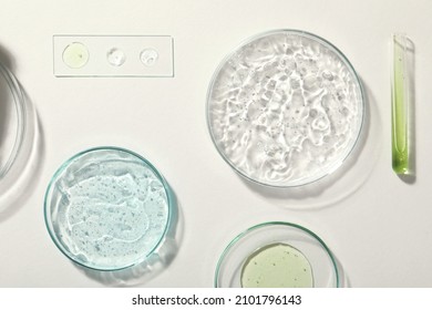 Flat lay composition with cosmetic gel and laboratory glassware on white background