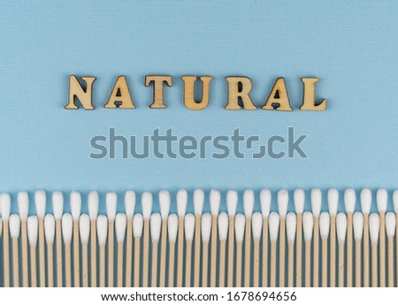 Flat lay composition with cotton swabs on blue background. natural cotton sticks made from cotton and cane. hygiene and sanitation. Top view ear sticks. 