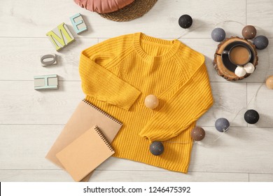 Flat lay composition with cozy knitted sweater on wooden floor - Shutterstock ID 1246475392