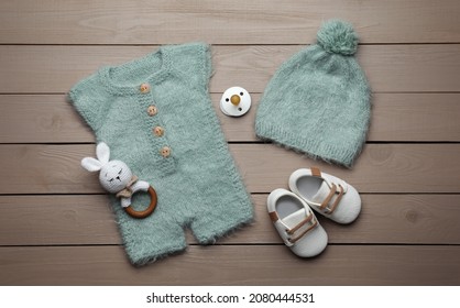 Flat Lay Composition With Cute Baby Knitwear For Photoshoot On Wooden Background