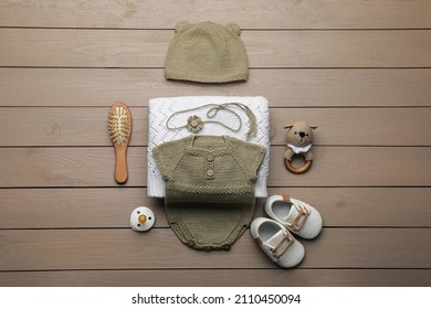 Flat Lay Composition With Cute Baby Knitwear For Photoshoot On Wooden Background