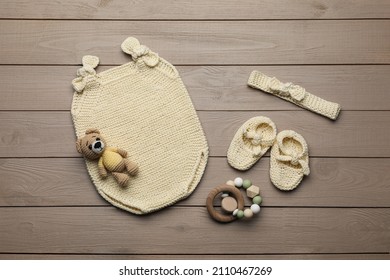 Flat Lay Composition With Cute Baby Knitwear For Photoshoot On Wooden Background