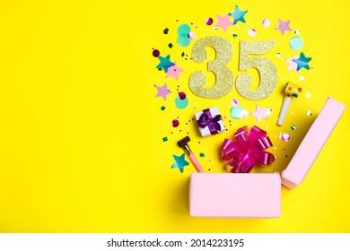 Flat lay composition with decor and numbers on yellow background, space for text. 35th birthday party