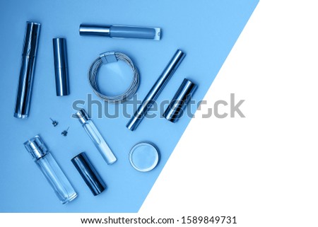 Flat lay composition with decorative makeup products and parfume on trendy blue and isolated white background. Makeup and beaty concept. Mockup for your design. Color of the year 2020 concept. Copy