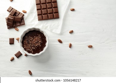 Flat lay composition with delicious chocolate on wooden background