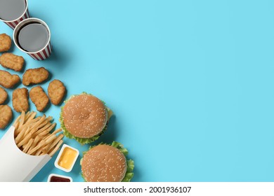 Flat Lay Composition With Delicious Fast Food Menu On Light Blue Background. Space For Text