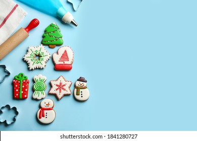 Flat lay composition with delicious gingerbread cookies and kitchen items on light blue background. Space for text