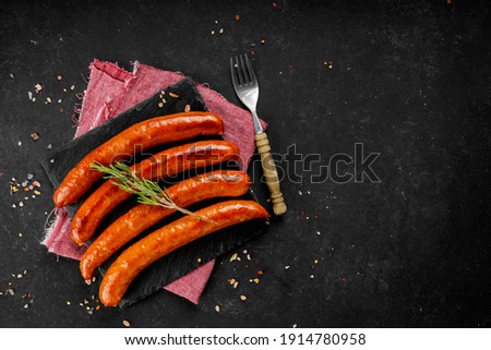 Flat lay composition of delicious hot dogs and sandwiches with different toppings on the dark background