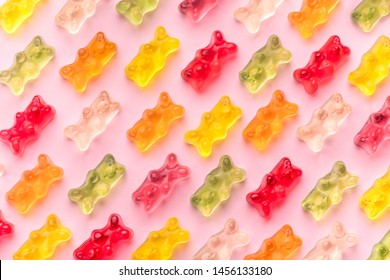 Flat lay composition with delicious jelly bears, jelly bears pattern on pink background