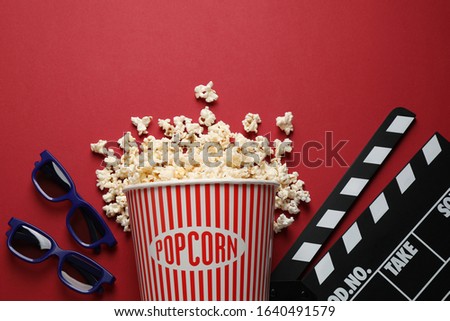 Flat lay composition with delicious popcorn on red background