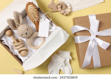 Flat lay composition with different baby accessories and blank card on yellow background