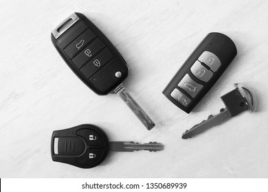 Flat lay composition with different car keys on light background, top view