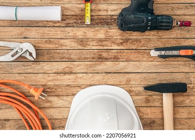 Flat lay composition with different construction tools on wooden background.