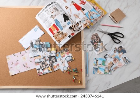 Flat lay composition with different photos, magazines and stationery on white marble background. Creating vision board