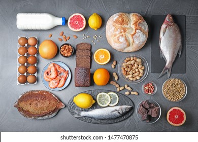 Flat lay composition with different products on dark grey background. Food allergy concept