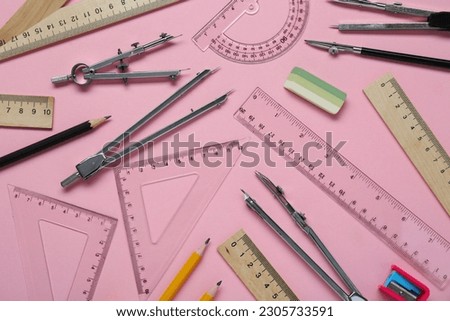 Flat lay composition with different rulers and stationery on pink background