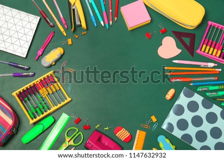 Flat lay composition with different school stationery on chalkboard surface