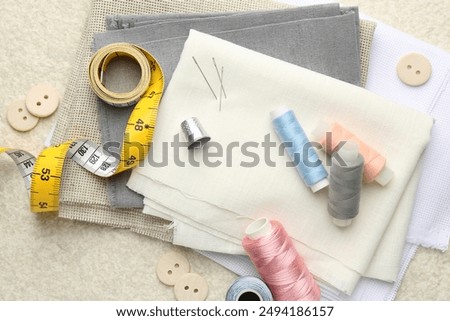Flat lay composition with different sewing supplies on light textured table