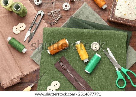 Flat lay composition with different sewing supplies on wooden table