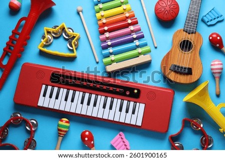 Flat lay composition with different toy musical instruments on light blue background