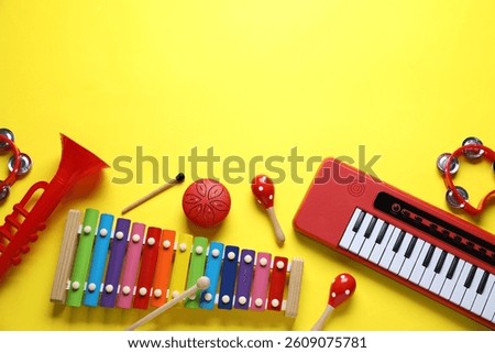 Flat lay composition with different toy musical instruments on yellow background. Space for text