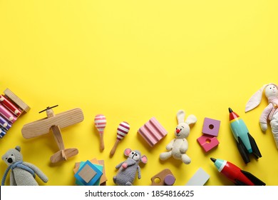 Flat lay composition with different toys on yellow background. Space for text
