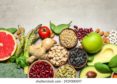 Flat lay composition with different vegetables, seeds and fruits on grey table, space for text. Healthy diet