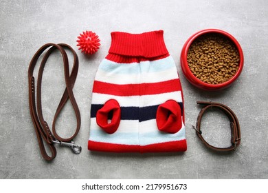 Flat lay composition with dog clothes, food and accessories on grey table