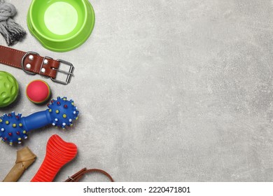 Flat Lay Composition With Dog Collar, Toys And Bowl On Grey Table. Space For Text