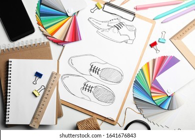 Flat lay composition with drawing of shoes on white table. Designer's workplace - Powered by Shutterstock