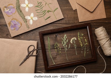Flat lay composition with dried flowers and plants on wooden table