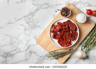 Flat lay composition with dried tomatoes and space for text on marble table