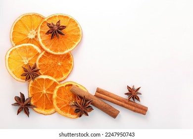 Flat lay composition with dry orange slices, anise stars and cinnamon sticks on white background. Space for text